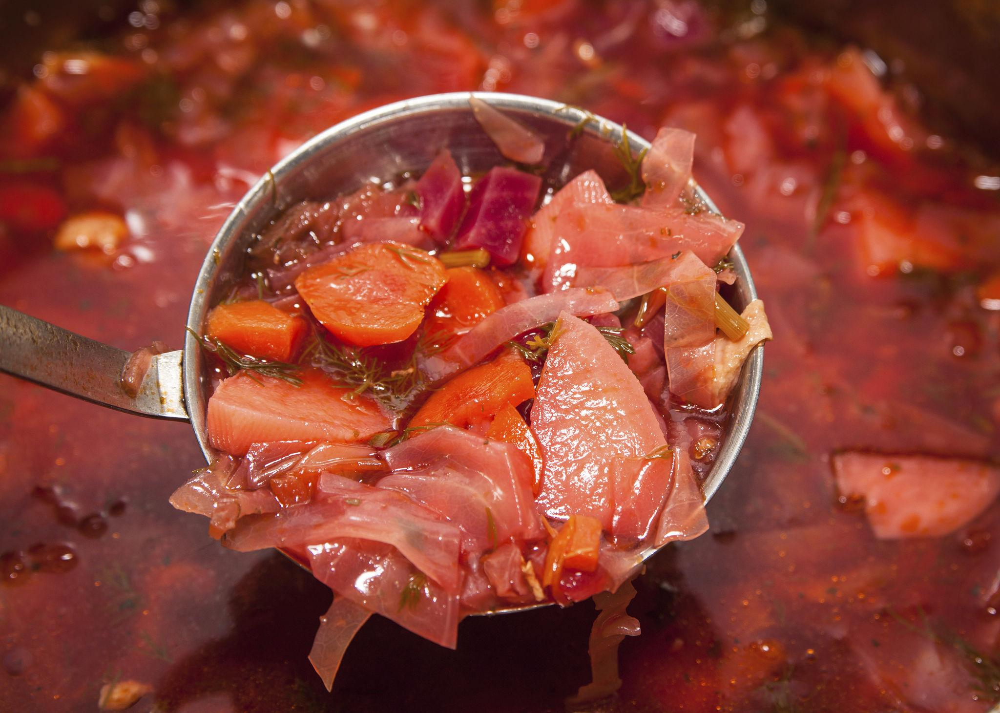 Ladle lifting a scoop of borscht from the pot